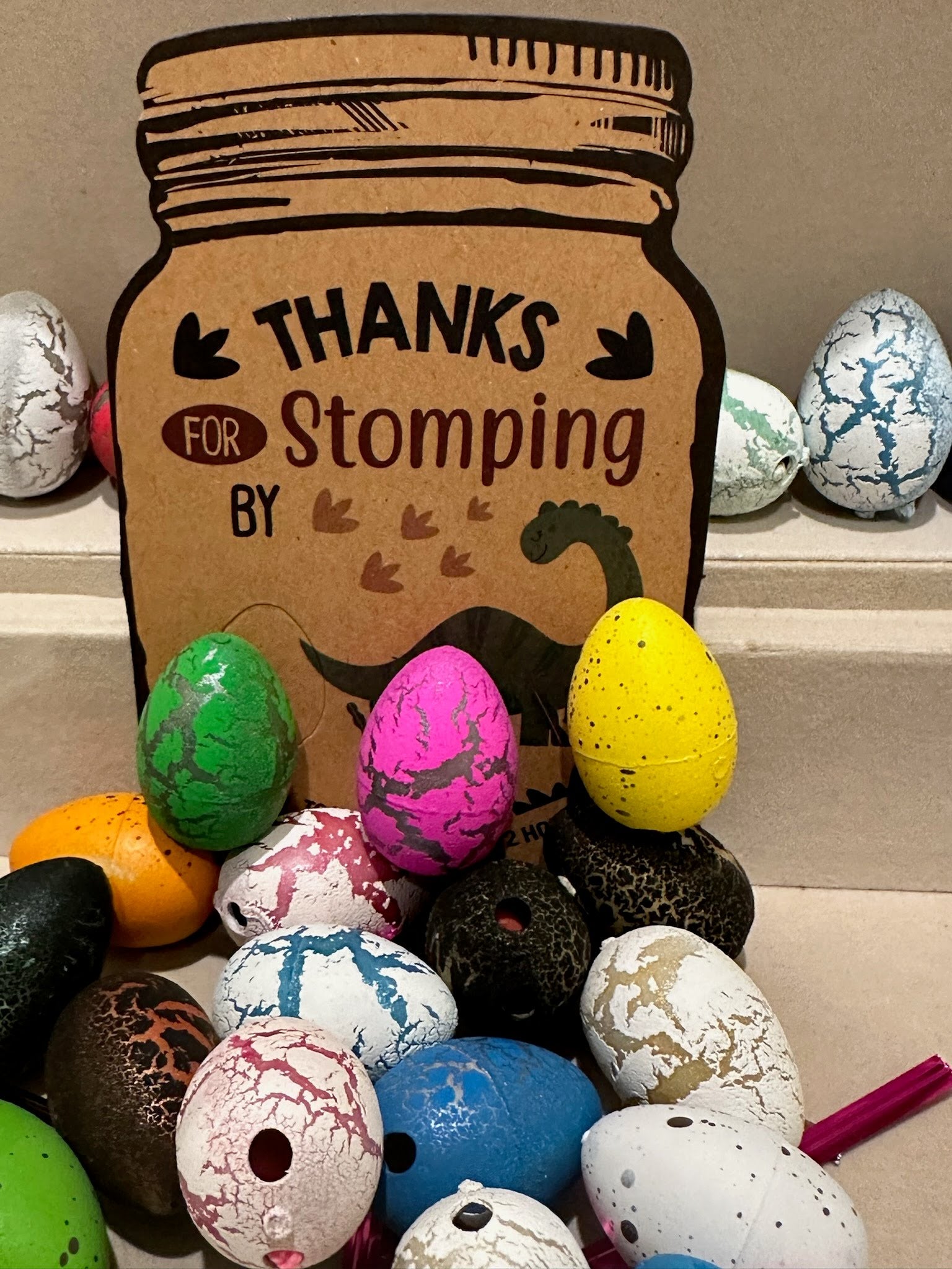 Close-up of colorful crackle-textured dinosaur eggs with a “Thanks for Stomping By” tag, ideal for dinosaur-themed party favors or kids’ goodie bags.